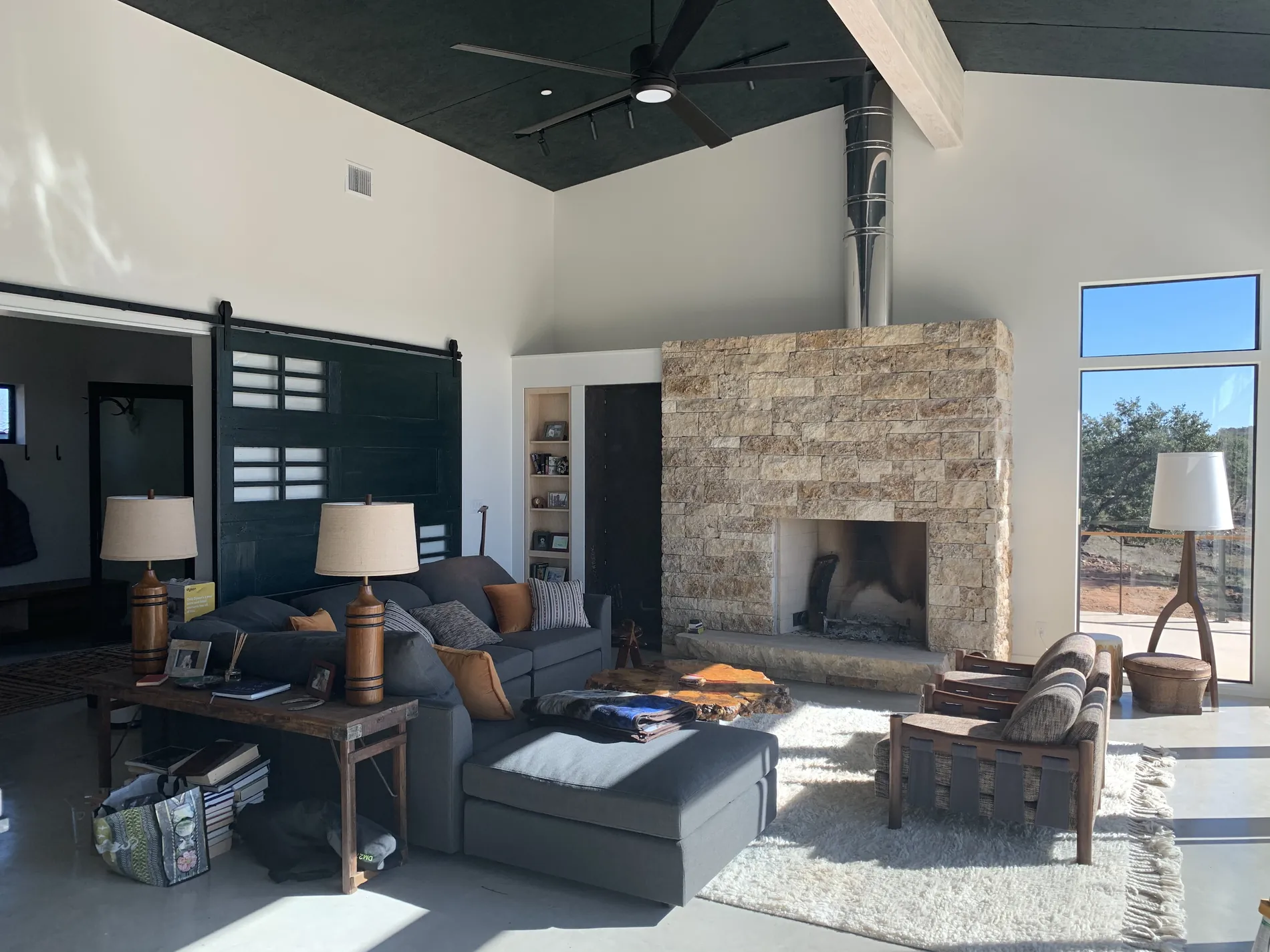 Finished cabin interior with cathedral ceiling and stone fireplace